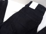 the back of a pair of black jeans sitting on top of a white surface