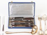 a box with a set of silverware in it on a white surface