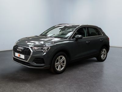 une Audi QX grise garée dans une grande pièce