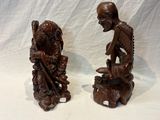 deux figurines d'un homme et d'une femme assis sur un rocher