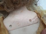 a close up of a doll ' s neck with a tag on it