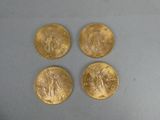 quatre pièces d'or posées sur une surface blanche