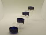 trois bols en verre bleu posés sur des socles en acrylique transparent