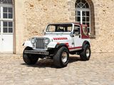 a white jeep parked in front of a stone building