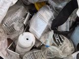 a bag full of plastic bottles and other items in it