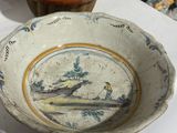 a bowl with a painting on it sitting on a table