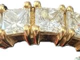 an image of a gold ring with three princess cut diamonds on it