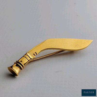 une image représentant un couteau plaqué or posé sur une surface blanche