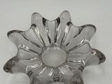 an image of a clear glass flower shaped dish on a white surface