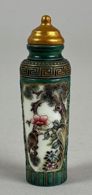 a green vase with a gold lid sitting on a table