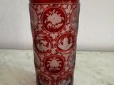 un verre rouge décoré d'un motif, posé sur une table