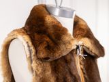 a mannequin with a fur vest on a mannequin stand