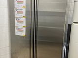 a stainless steel refrigerator in the corner of a kitchen