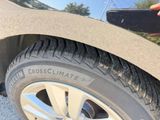 someone is holding a cell phone up to a tire on a road
