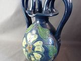 a blue vase with a green and yellow design on it
