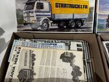 two boxed boxes of model trucks sitting on a table