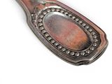 a silver spoon with a metal handle on a white surface
