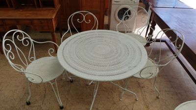 une photo d'une table et de chaises blanches dans une cuisine