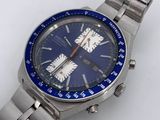 a silver watch with a blue face on a white surface