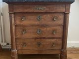 a wooden chest of drawers with a clock on top of it