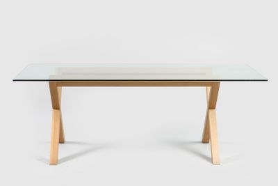 une table en verre avec des pieds en bois et un plateau en verre
