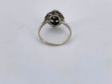 a close up of a ring with a black stone in it