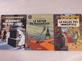 Trois livres pour enfants sont posés sur une table devant un fond blanc.