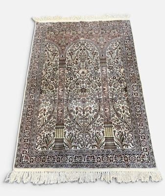 un tapis oriental aux motifs complexes et aux franges, sur fond blanc