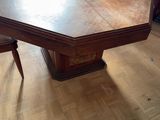 une grande table en bois et des chaises dans une pièce