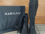 the boots are next to a bag and a pair of shoes