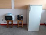 un réfrigérateur blanc et un micro-ondes dans une petite pièce