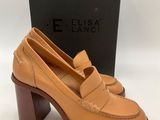 une paire de chaussures en cuir beige à talon en bois et une boîte