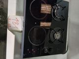a black stove top with two burners on it and a roll of toilet paper on the side of the stove