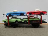 deux petites voitures à l'arrière d'un camion à plateau