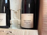 three bottles of wine sitting in a box on a table