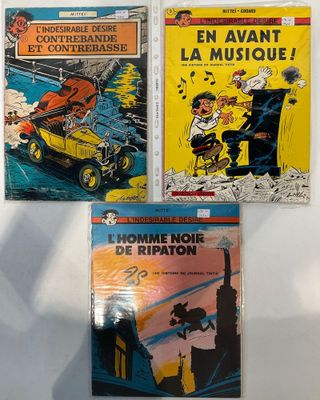 trois bandes dessinées sont exposées sur une surface blanche
