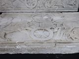 a stone carving of a horse and carriage with a dragon on it