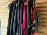 several jackets hanging on a rack in a room