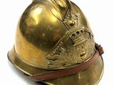 brass fireman ' s helmet on a white background with a leather strap