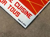 a red and yellow sign on the ground with a black and white picture