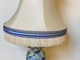 une lampe de table bleue et blanche, surmontée d'un abat-jour blanc