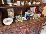 a wooden china cabinet with many items on top of it