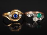 deux bagues en or ornées de pierres bleues et vertes sur un fond noir
