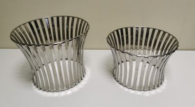 two silver vases sitting on top of a table next to each other