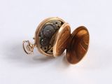 a small pocket watch inside of it on a white surface