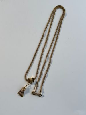 deux colliers en or ornés de pompons sur un fond blanc