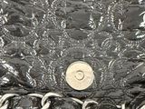 a coin sitting on top of a shiny black purse