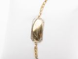 gros plan d'un bracelet en or sur un oreiller blanc