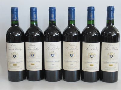 six bouteilles de vin rouge sont alignées sur une table
