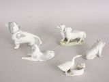 five figurines of animals on a white surface
